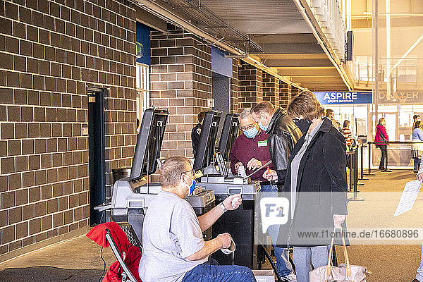 Wähler  die ihre Stimmzettel in die Auszählmaschinen einlegen.