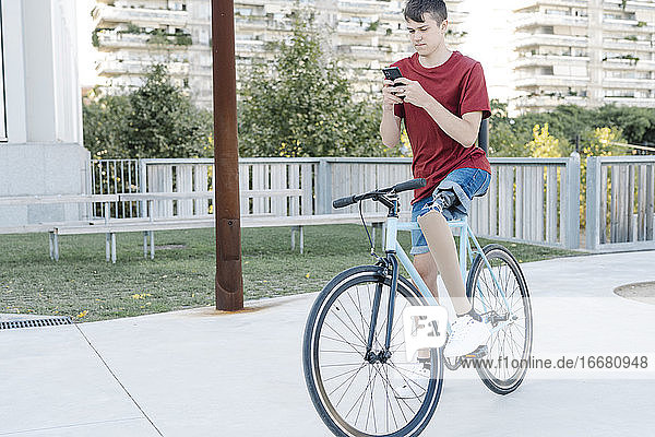 Behinderter Radfahrer benutzt Telefon auf der Straße