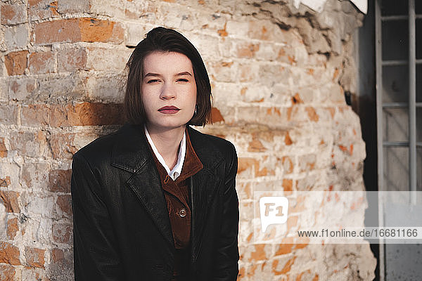 Young woman in leather jacket  low key portrait  grunge backgrou