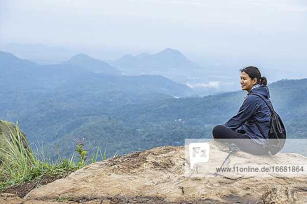Frau  die sich auf dem Gipfel des Adam's Peak in der Nähe von Ella in Sri Lanka ausruht