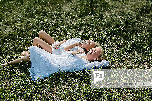 Lachende Dorfkinder im Gras liegend