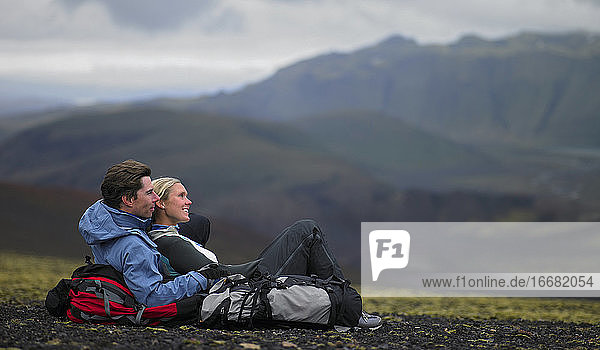 Hiking couple relaxing on mountainside in Iceland