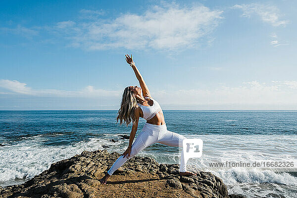 Junge Frau in Yoga-Pose am Strand