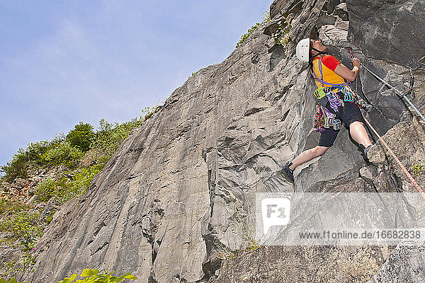 woman climbing limestone cliff in South Wales