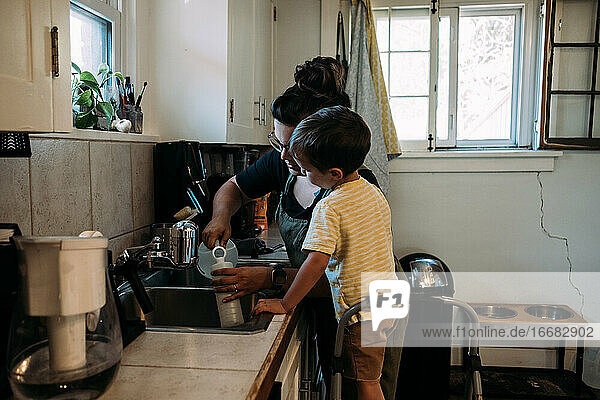Mutter und Kind arbeiten gemeinsam an der Küchenspüle