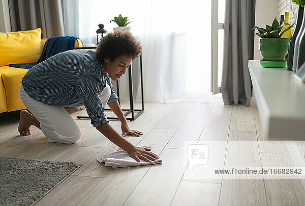 Ethnische Frau wäscht den Boden zu Hause