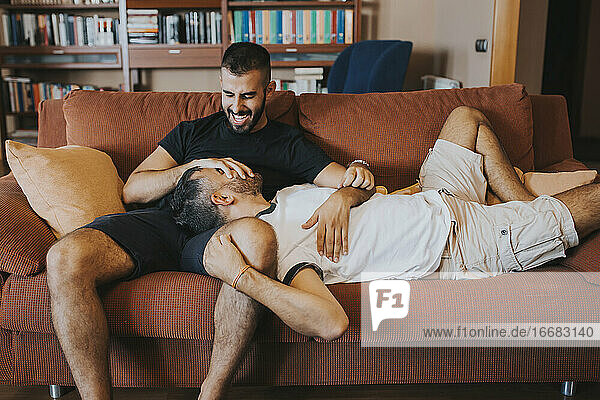 Homosexuelles Paar  das Spaß hat und auf der Couch lacht