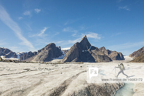 Mountaineer crosses a river on the Caribou Glacier  Baffin Island