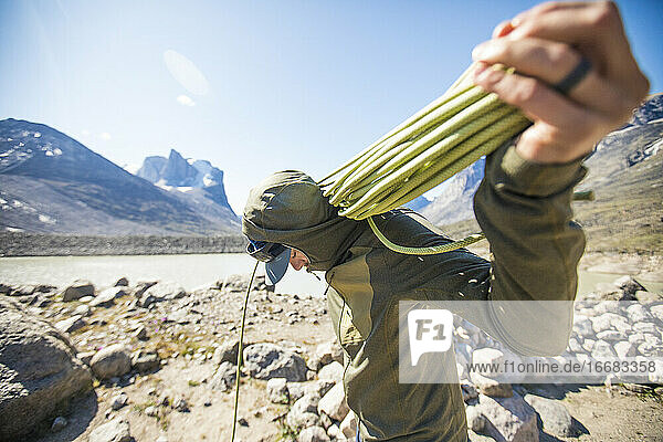 Climber prepares rope for another day of climbing on Baffin Island.
