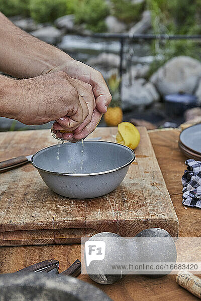 Chefkoch presst Zitrone beim Grillfest auf dem Campingplatz aus