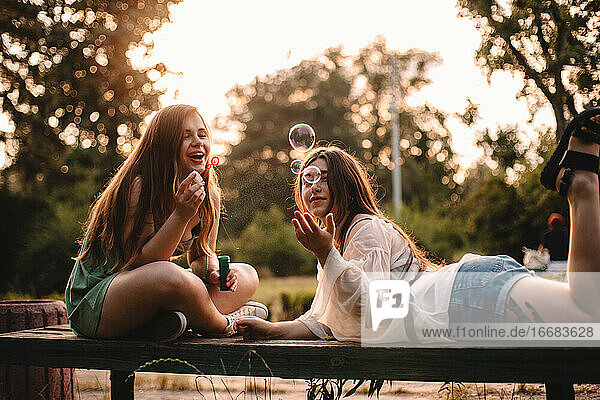Glückliche lesbische Paar spielt mit Blasen im Park im Sommer entspannen