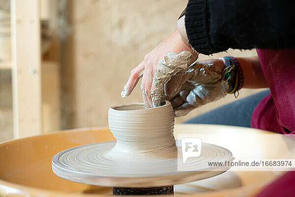 Keramikkünstlerin bei der Arbeit in ihrem Atelier mit der Töpferscheibe