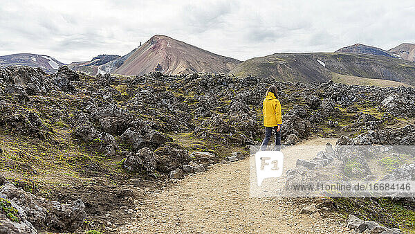 Junge Frau wandert auf dem felsigen Pfad Landmannalaugar in Island