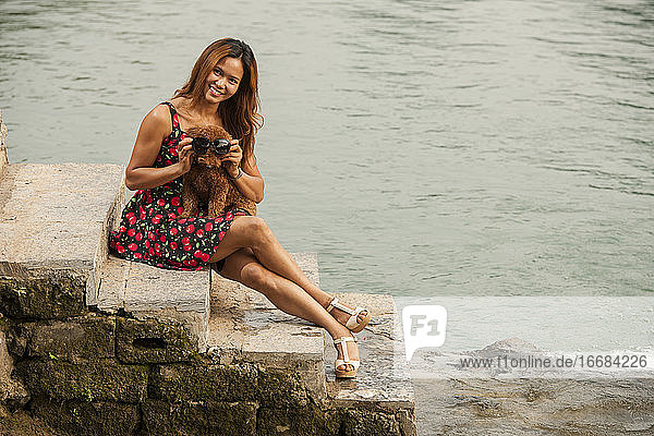 schöne Frau mit ihrem Hund am Ufer des Flusses Li in Yangshuo