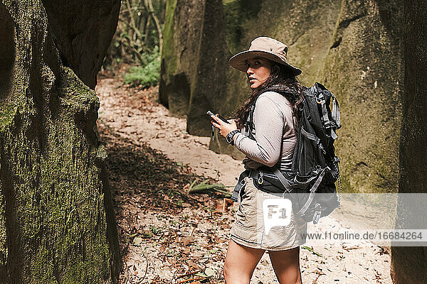 Woman with gps and backpack looking back.