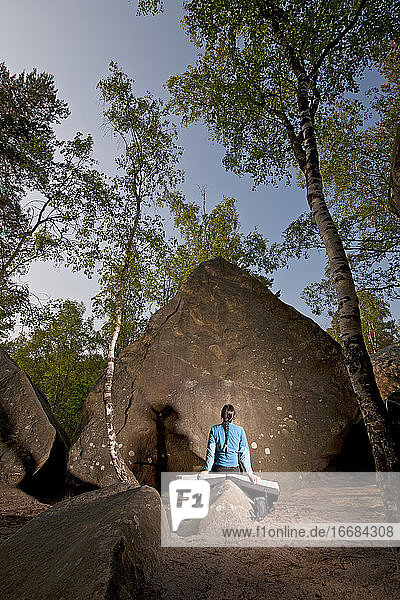 Reife Frau bei der Vorbereitung zum Bouldern im Wald von Fontainebleau