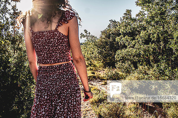 junges Mädchen in der Mitte des Waldes mit Sonne Brise