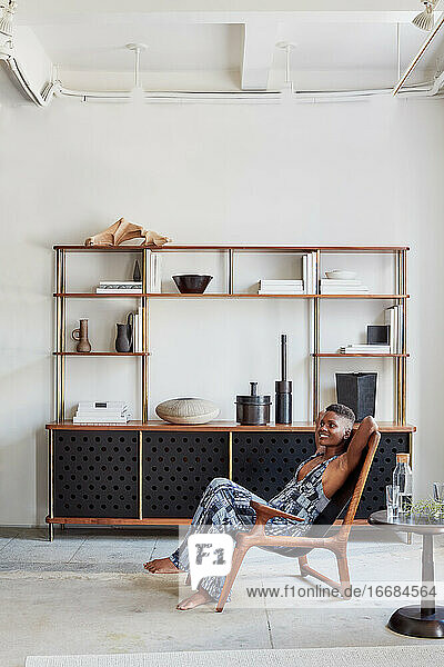 Woman lounging in wood chair with bespoke livingroom console