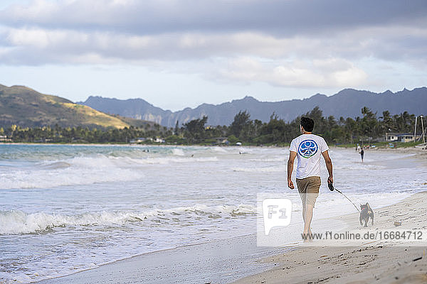 Mann geht mit seinem Hund am Strand in Kailua  Hawaii  spazieren