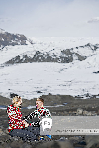 junges Paar beim Picknick in karger Landschaft in Island