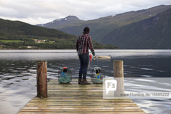 Ein Fischer begutachtet die Szene auf der anderen Seite des Fjords