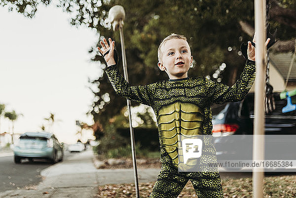 Young boy dressed as sea monster playing in costume at Halloween