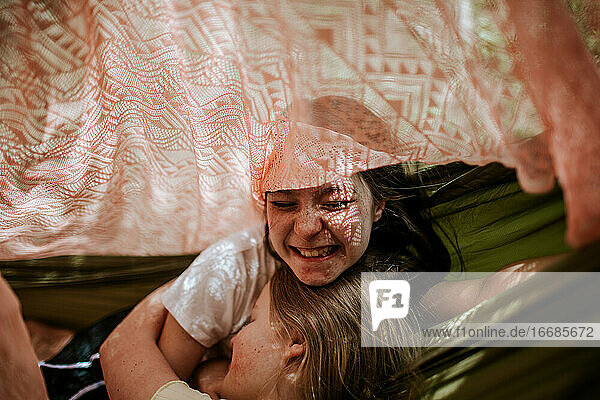 Teen girls laughing and hugging in tent