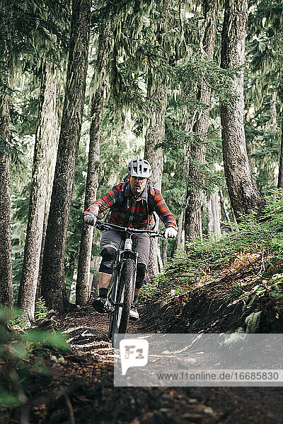 A young man rides his bike downhill at Mt. Hood  Oregon.