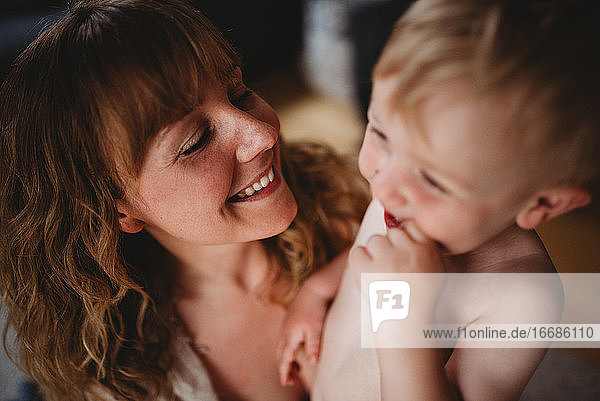 Close up von schönen blonden Mutter und Sohn lächelnd und umarmt zu Hause