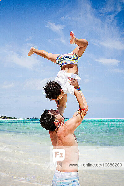Father and son playing at a beach in the Caribbean.