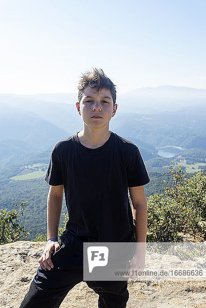 Porträt eines jungen Mannes mit schwarzem T-Shirt vor einem Gebirge