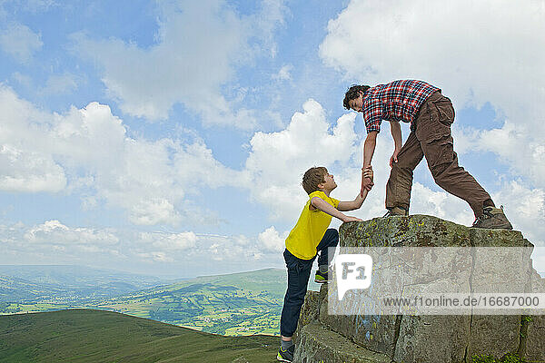 Jugendlicher hilft seinem Freund beim Klettern