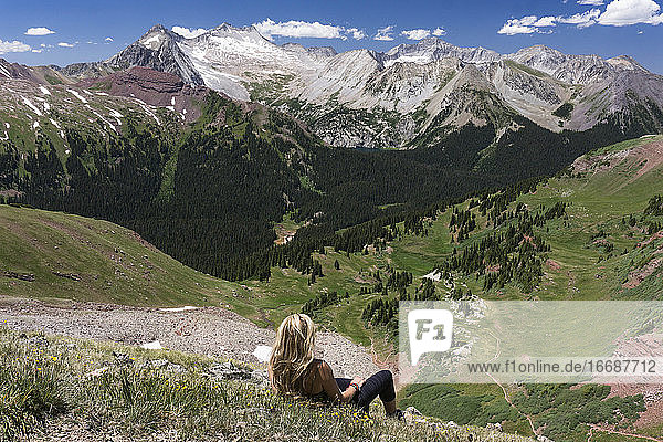 Wanderin betrachtet die Aussicht beim Entspannen auf einem Berg