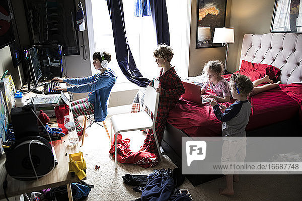 Vier Geschwister hängen im unordentlichen Schlafzimmer eines Teenager-Bruders herum