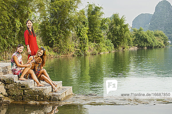 drei schöne Frauen posieren neben dem Fluss Li in Yangshuo