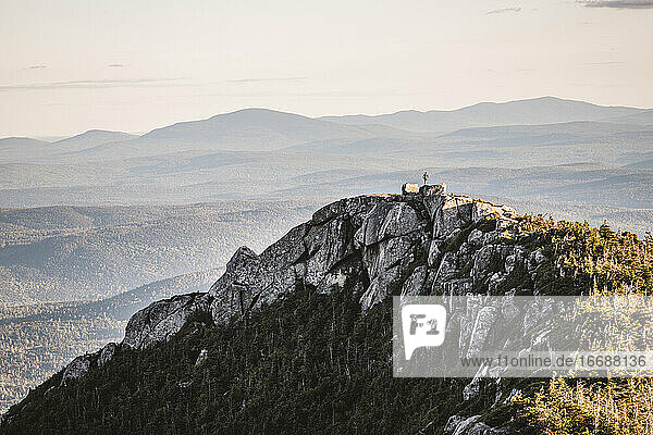 lonely hiker stands on rocky peak in Baxter State Park Maine