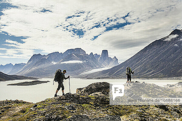 Rucksacktouristen überqueren einen Bergkamm am Akshayak-Pass auf Baffin Island.