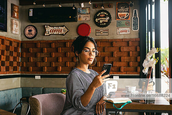 woman checking her cell phone while having coffee  chill concept