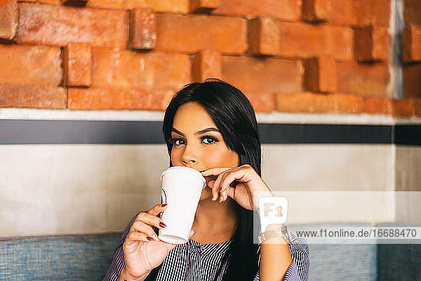 frau genießt einen kaffee  latina mit durchdringendem blick