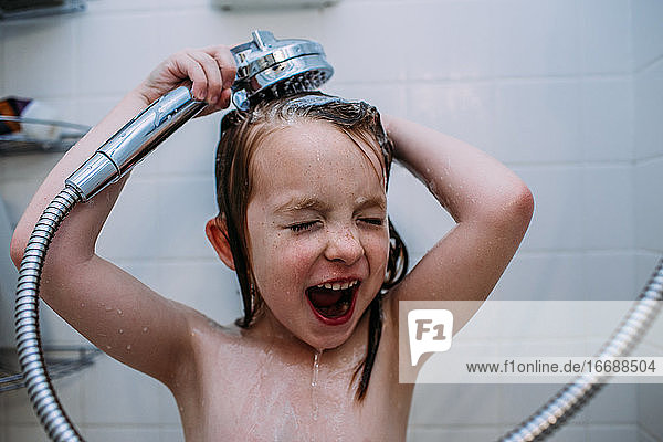 Nahaufnahme eines jungen Mädchens  das sich in der Dusche das Shampoo aus dem Haar spült