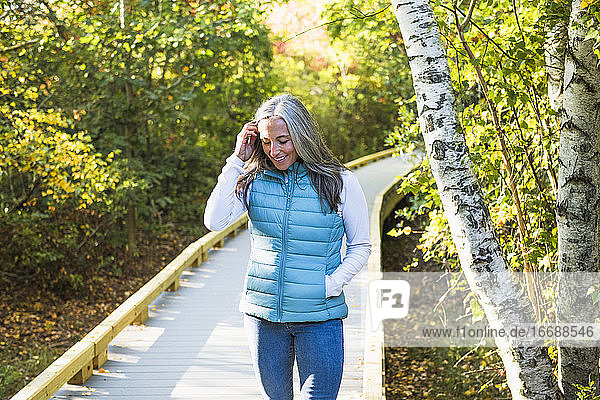 Grauhaarige Frau genießt einen Spaziergang in der Natur