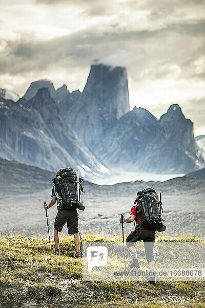 Two climbers hike toward Mount Asgard in Akshayak Pass