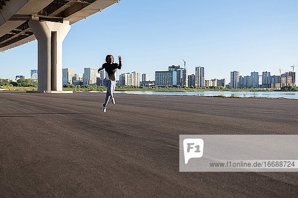 Schwarzer Läufer springt unter Brücke