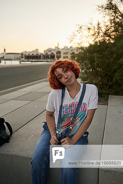 Junges alternatives rothaariges Mädchen posiert bei Sonnenuntergang in einem Overall