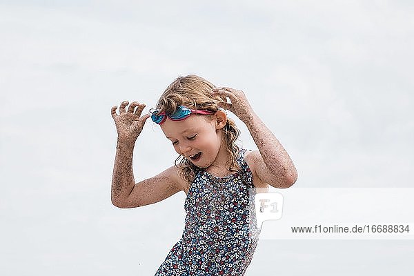 girl with goggles on dancing having fun at the beach in summer