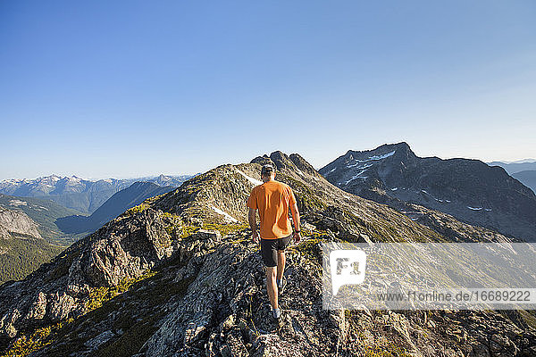 Rückansicht eines Mannes beim Trailrunning auf einem Bergkamm  B.C.  Kanada.