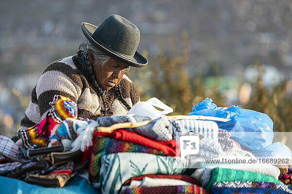 Senior female vendor selling sweaters  Cusco  Peru