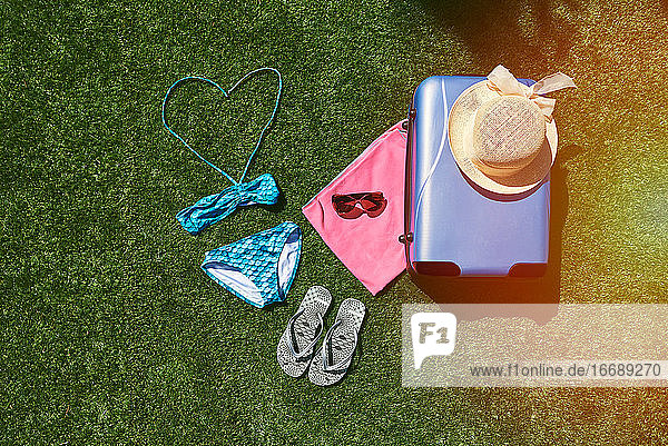 Reisegepäck für den Sommerurlaub mit Gras im Hintergrund.