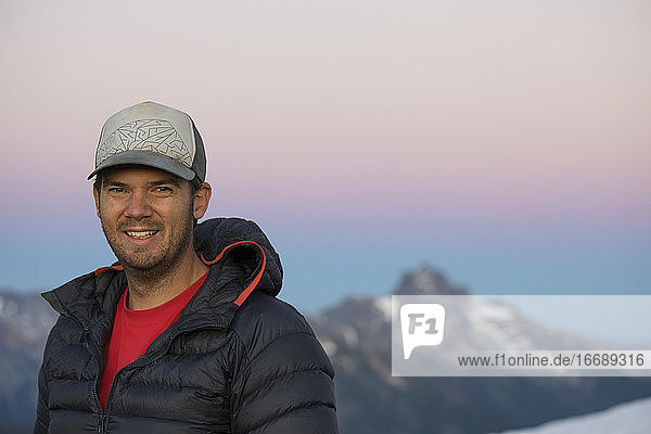 Porträt eines aktiven Mannes  der in den Bergen lächelt.