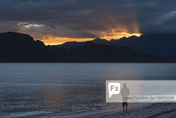 Eine Person spaziert bei Sonnenuntergang am Strand der Insel Carmen  Loreto  Baja California  Mexiko.